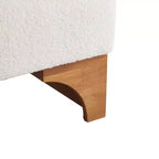 Poltrona d'accento con schienale arrotolato e base in legno massello, rivestimento in bouclé